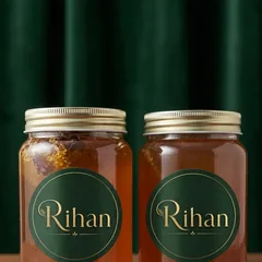 دو شیشه عسل طبیعی هوراند با درب طلایی و برچسب ریهان روی میز چوبی - خرید عسل ارسباران